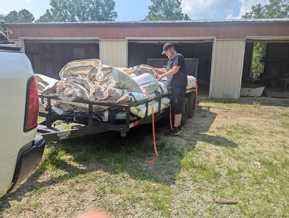 Crew tossing renovation debris into the large dump trailer mid-load.