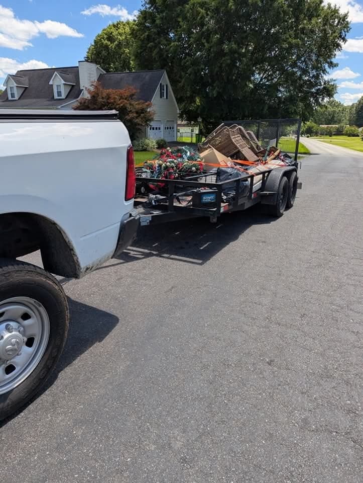 House cleanout haul with stacked chairs, totes, and mixed household junk.